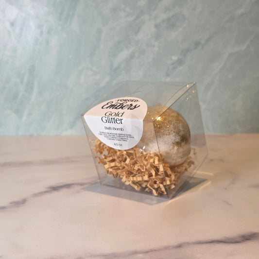 Gold Glitter Bath Bomb 
Turn your bath into a golden celebration! This fizzy beauty combines a bright, uplifting citrus blend with subtle floral notes, leaving your senses refreshed and your mood glowing. Topped with cosmetic-grade glitter, it transforms your tub into a shimmering, luxurious escape—because your bath should be as fabulous as you are!